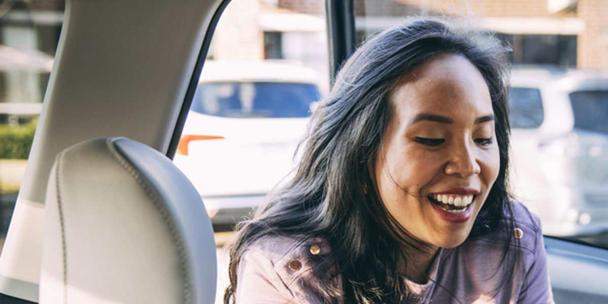 Woman smiling in the back seat of car